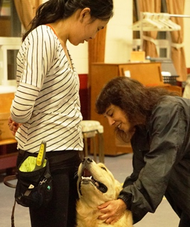 Anne Menon working with a student and her golden retriever